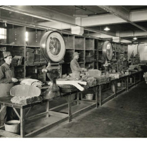Workers cutting and weighing processed rubber